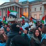 a large group of people with flags in front of a building